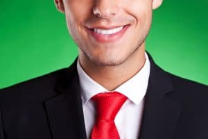 cropped image of a young business man smiling, over green background